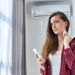 Woman holding HVAC remote
