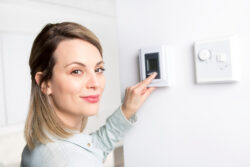 woman adjusting a thermostat