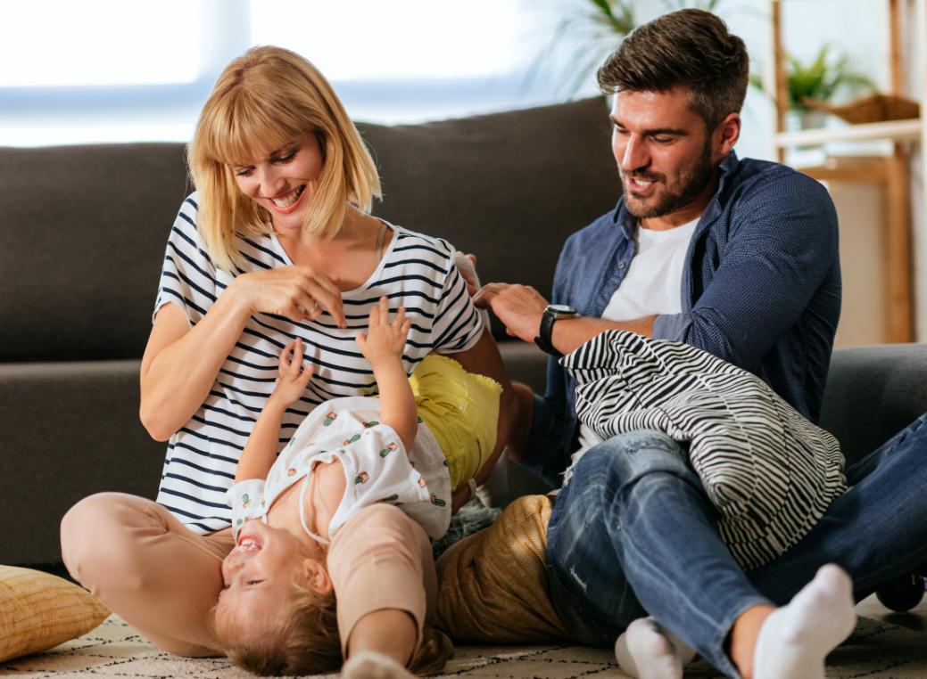 parents playing on couch with toddler