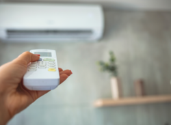 hand adjusting a ductless mini split remote