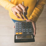 hand doing math on a calculator